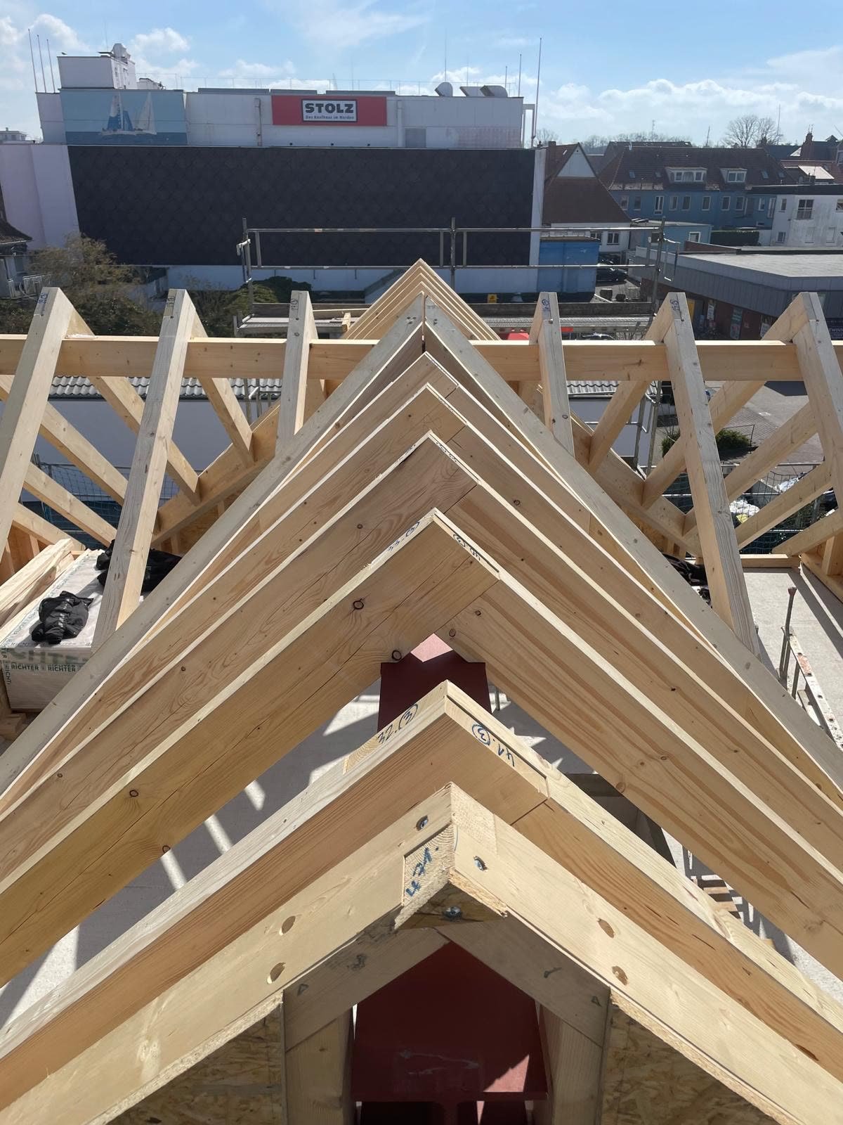 Nahaufnahme mehrerer passgenau aufgerichteter Holzbinder eines Dachstuhls